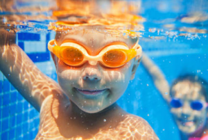 Zwei Kinder tauchen im Schwimmbad mit Taucherbrille