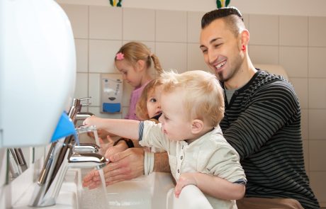 Mann und Kinder waschen ihre Hände