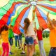 Kinder spielen unter Fallschirm